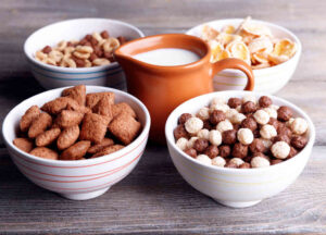 Various sweet cereals in ceramic bowls and jug with milk cereal food organic